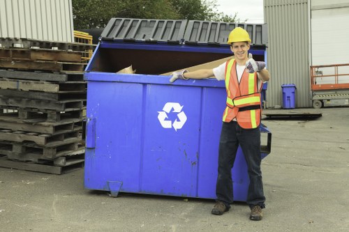 Supervisor conducting a site risk assessment and marking exclusion zones around a skip