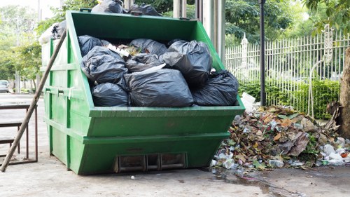 A skip being loaded with construction debris in Swiss Cottage